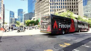 Calle del centro de San Francisco con el skyline y un colectivo con publicidad de una startup